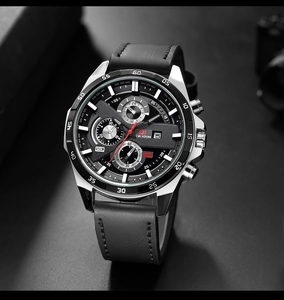 Detail of multi-function chronograph watch with black dial and date window on silver case