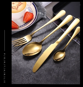 Detail view of 4-piece gold mirror stainless steel cutlery set on stone background