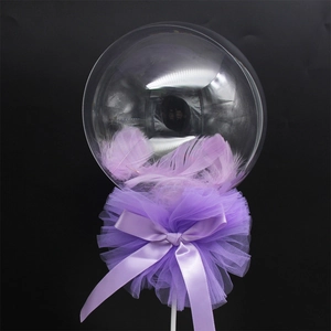 Close-up of 5-inch transparent cake balloon filled with purple feathers and bow