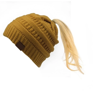 Dettaglio del berretto in maglia giallo zenzero per coda di cavallo con patch