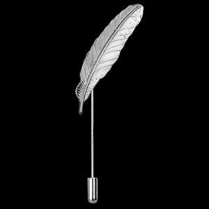 Macro detail of silver feather brooch with intricate textures on a black background