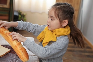 Detailed knit texture of a cozy yellow ribbed scarf worn by a little girl