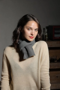 Detail shot of a grey knitted scarf with a soft wool texture shown in a portrait view