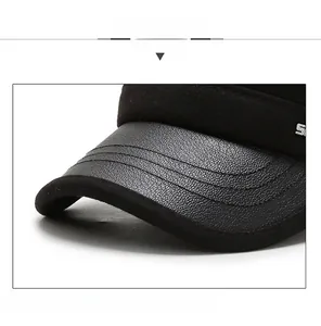 Detail of winter flat cap showing the textured faux leather brim and durable stitching