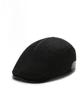 Detail of black wool newsboy hat featuring premium leather trim and metal rivets