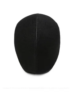 Detailed top view of a black wool felt newsboy cap with stitching detail on white background