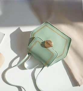 Macro detail of mint green geometric handbag showing PU leather texture and gold buckle