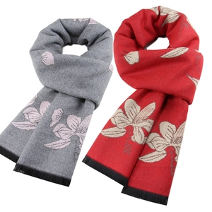 Détail d'écharpes rouges et grises à motifs floraux et finitions à franges élégantes