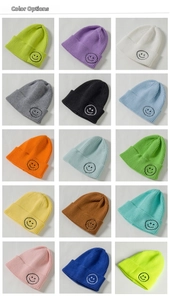 Close-up of ribbed knit beanie collection showing colorful options and smiley embroidery