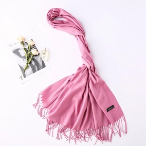 Close-up of pink cashmere scarf texture with fringe details and elegant props