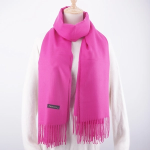 Detail shot of bright pink cashmere scarf with fringe and a premium quality brand label
