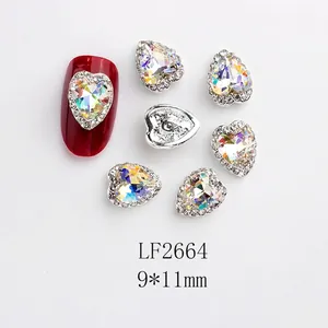 Détail d'un bijou d'ongle coeur aurore 9x11mm avec monture argentée sur un ongle rouge
