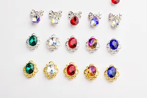 Détail de bijoux d'ongles en alliage avec cristaux colorés sur socles dorés et argentés
