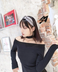 Detail of grey satin headband with crystal rhinestones worn by a model in soft lighting