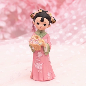 Detail of pink resin doll with hand-painted embroidery flowers and floral headpiece