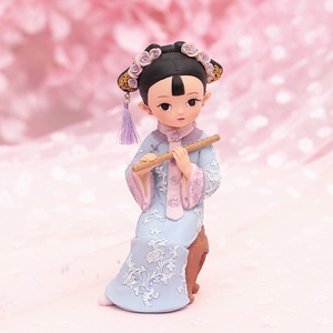 Detail of vintage palace girl figurine in blue and pink dress holding a flute
