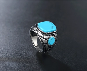Macro view of vintage titanium steel ring with turquoise inlay and carved textures