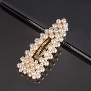 Barrette rectangulaire élégante avec perles blanches sur base dorée et surface sombre