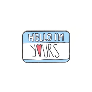 Detailed shot of an enamel brooch with Hello I'm Yours text on a white background