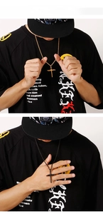 Detail view of gold and black titanium steel cross pendants worn on a model