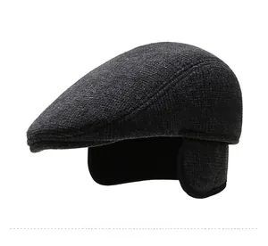 Detail view of dark grey winter newsboy hat with ear flaps and wool texture fabric