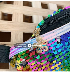 Dettaglio ravvicinato di paillettes a sirena colorate e zip dorata a forma di fiore sulla borsa