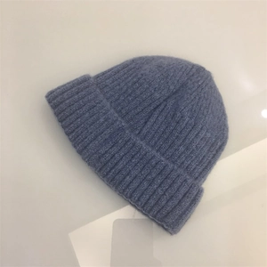 Close-up of blue knit beanie showing vertical ribbed texture and folded cuff detail