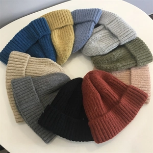 Detailed overhead view of various colorful ribbed knit beanie hats arranged in a circle