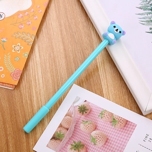 Cute blue bear cartoon gel pen on a wooden desk with stationery accessories