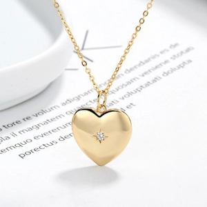 Detailed macro of golden heart pendant necklace with starburst zircon and fine O-chain