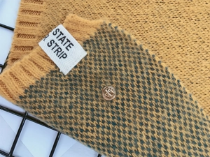 Gros plan sur la texture d'écharpe tricotée jaune et verte avec étiquette State Strip