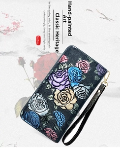 Detail showing colorful embossed rose patterns on the long leather wallet with hand strap