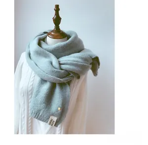 Détail de l'écharpe en maille vert menthe avec patch ananas et étiquette en tissu