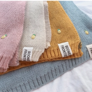 Détail de textures de écharpes en maille douce en plusieurs couleurs avec broches