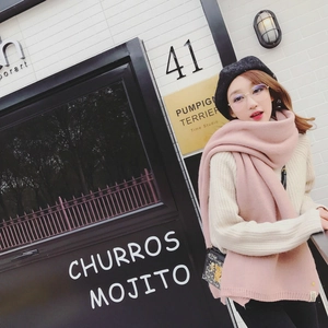 Photo en extérieur d'une écharpe en tricot rose avec un pull beige et un béret noir
