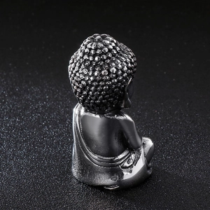 Polished stainless steel Buddha statue ornament in gunmetal finish on a dark background