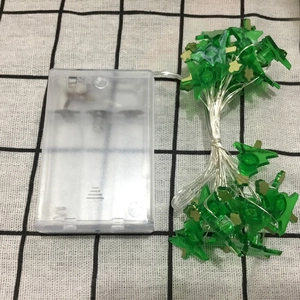 Detail of green star LED fairy lights with transparent AA battery box on checkered cloth