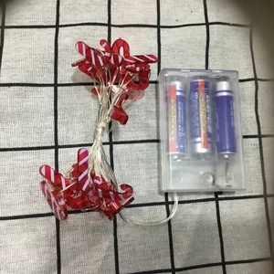 Close-up of candy cane LED string lights with red and white stripes and battery box