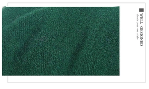 Macro detail of dark green wool felt fabric texture for warm winter beret hats