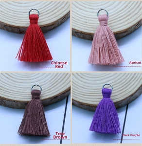 Detail of red, apricot, brown, and dark purple cotton tassels with silver metal rings