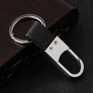 Premium black leather car keychain with silver metal D-ring on wood and leather surface