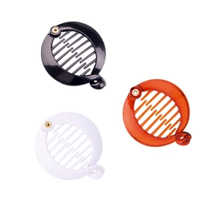 Three-piece set of round plastic hair clips in black, amber, and white with glossy finish
