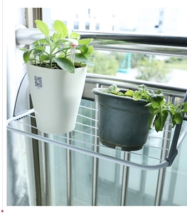 Detail of white metal radiator drying rack with grey hooks for balcony organization