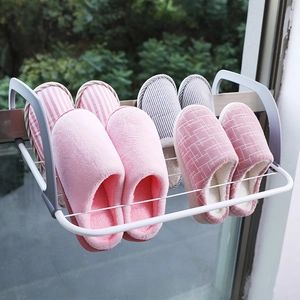 Folding iron drying rack on balcony balcony railing holding four pairs of home slippers