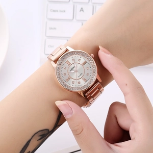 Gros plan sur la montre en or rose avec lunette en strass et cadran en argent