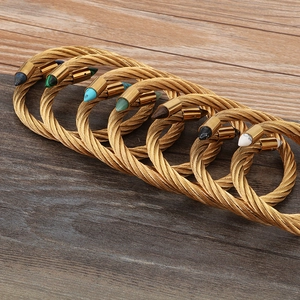 Fashionable twisted cable open bangles in gold finish with colorful stone end caps