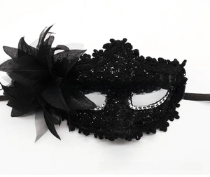 Detail of black lace masquerade mask with side flower and sparkling rhinestones