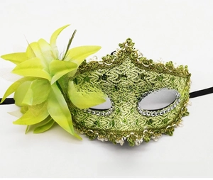 Detail of green lace masquerade mask featuring side flower ornaments and sequins
