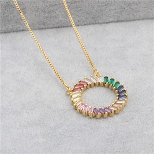 Detail of gold box chain necklace with circular pendant featuring colorful baguette zircons
