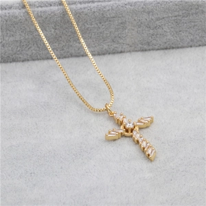 Close-up of gold box chain and cross pendant with zircon stones on a grey display tray